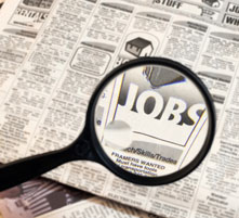 een krant en een vergrootglas dat het woord 'jobs' vergroot