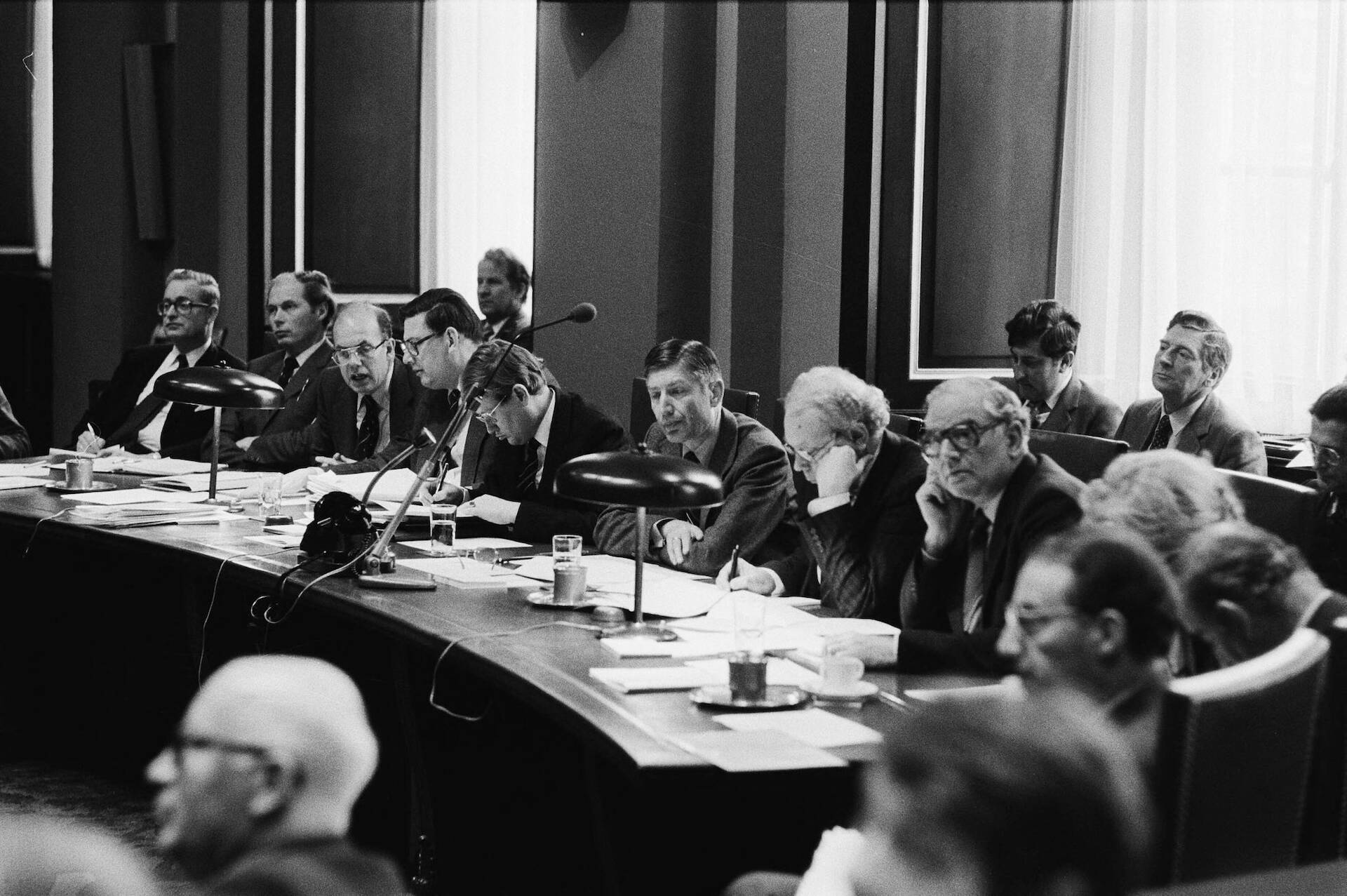 Zwart-wit foto met daarop groep mensen achter de regeringstafel in de Eerste Kamer