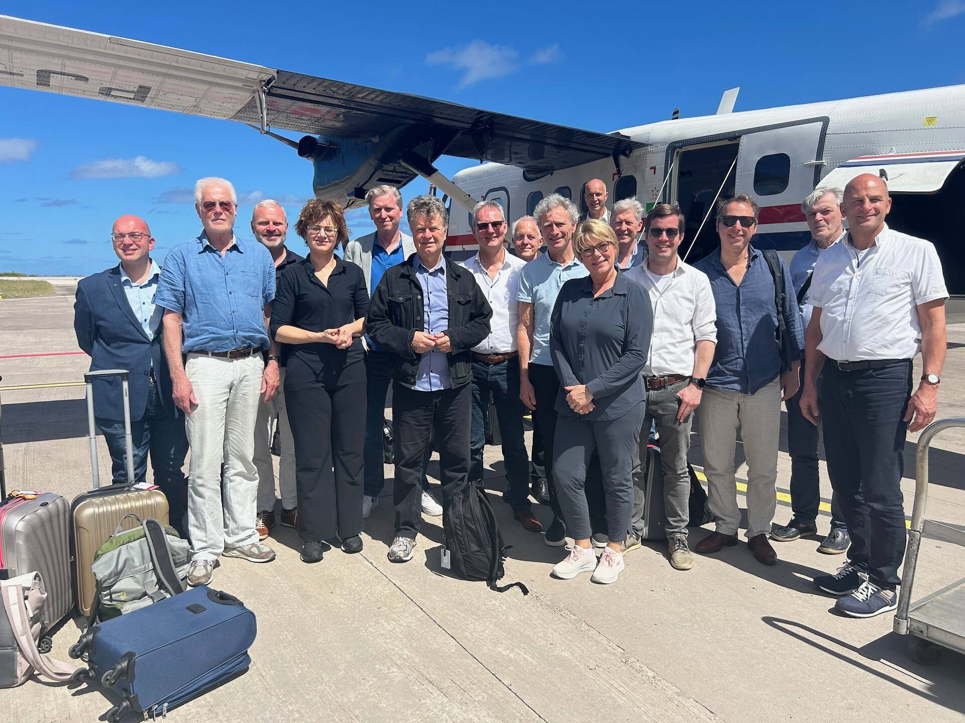 Foto van de Eerste Kamerdelegatie bij het vliegtuig na landing op Saba