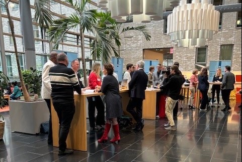 Foto van een gesprek tussen een grote groep medewerkers van de Belastingdienst en de twee Kamerleden